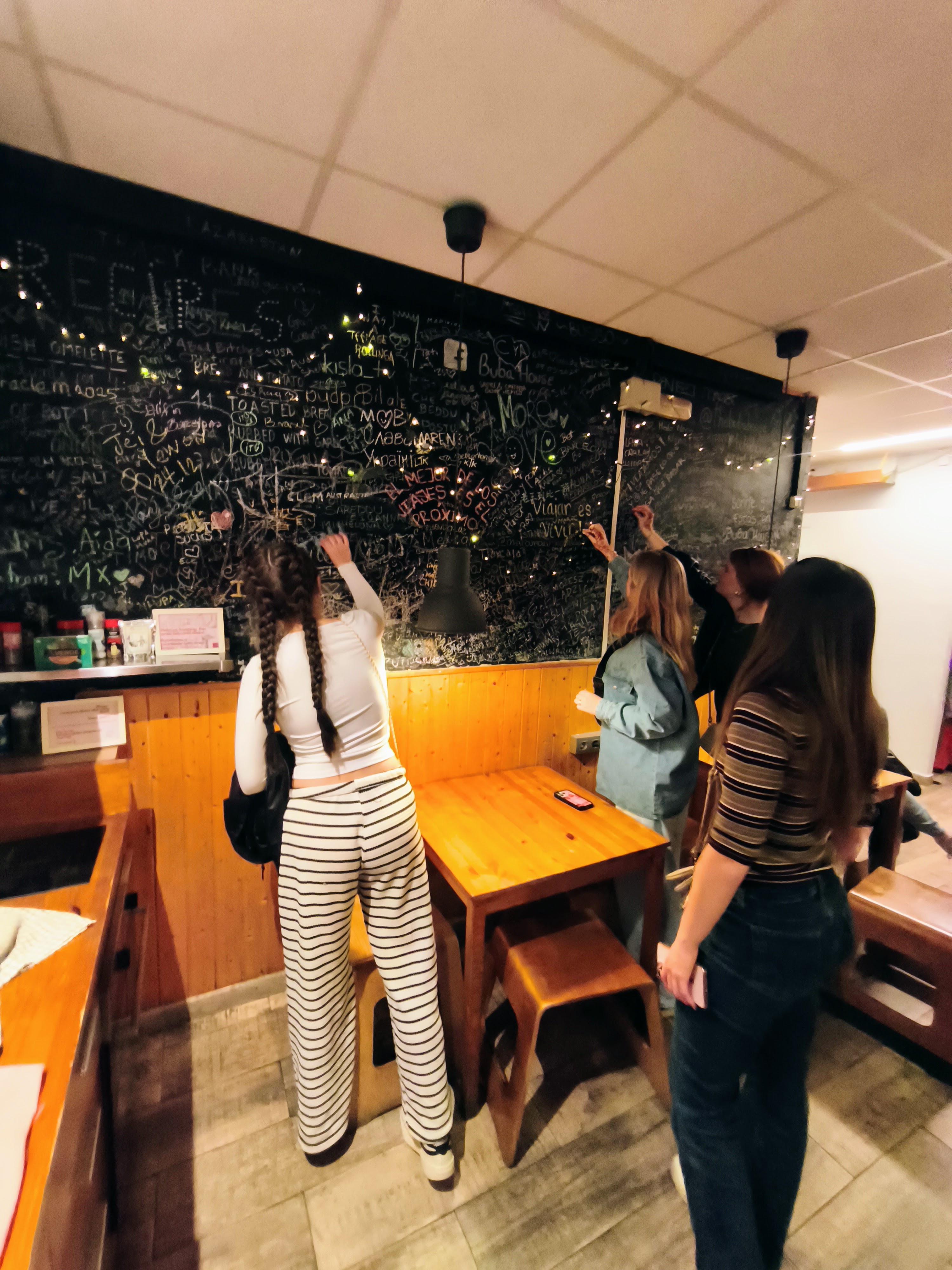 Guests writing on the chalkboard wall at Buba House Barcelona